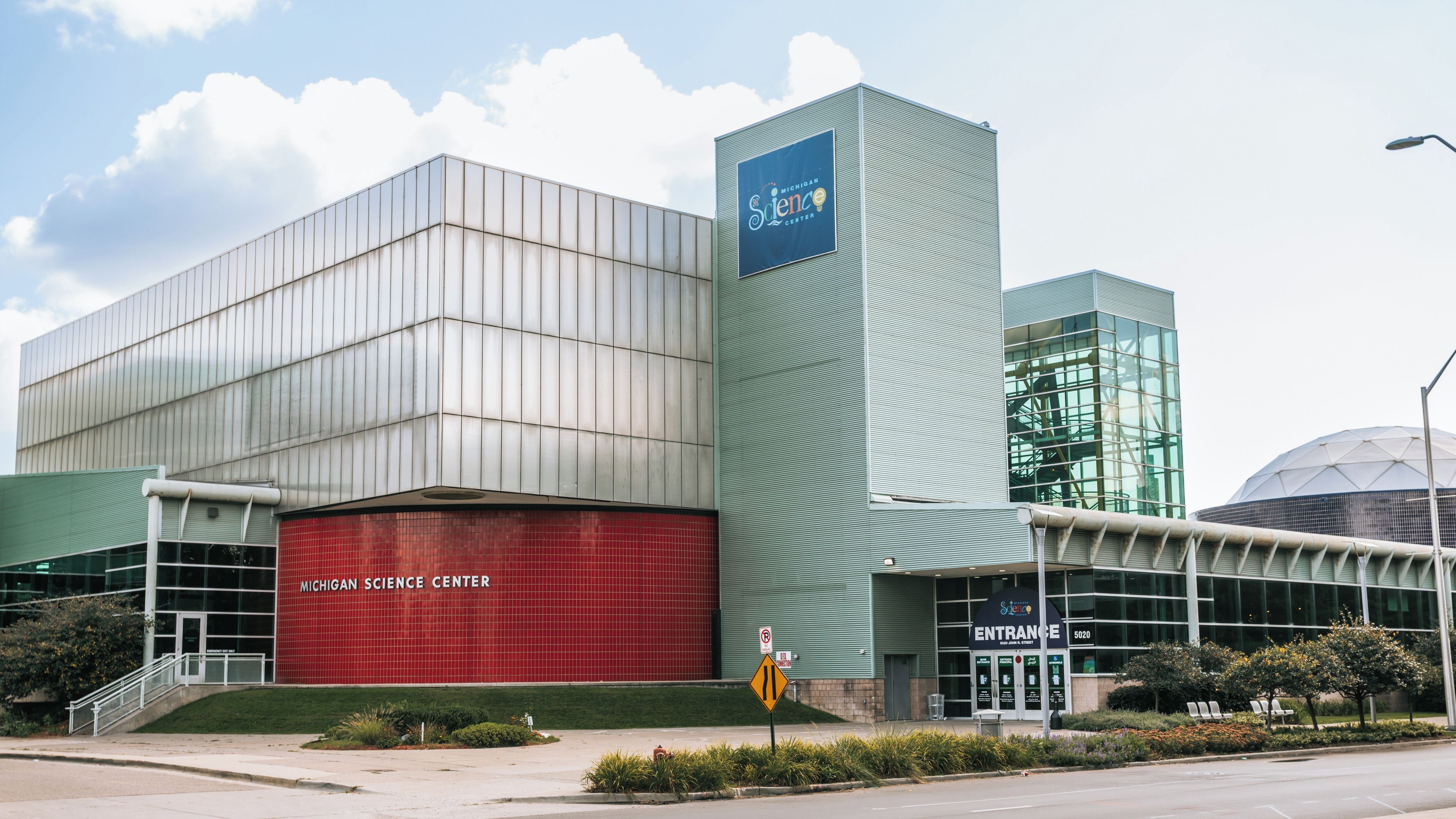Il Michigan Science Center con un edificio rosso ben visibile e una struttura verde.