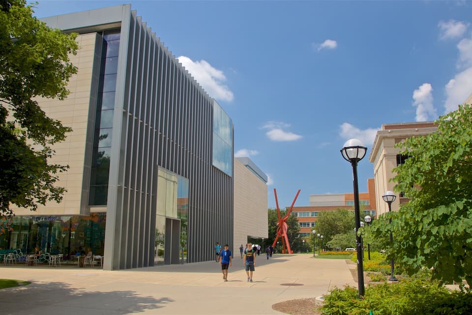 A modern building with vertical lines, a pathway, and greenery.