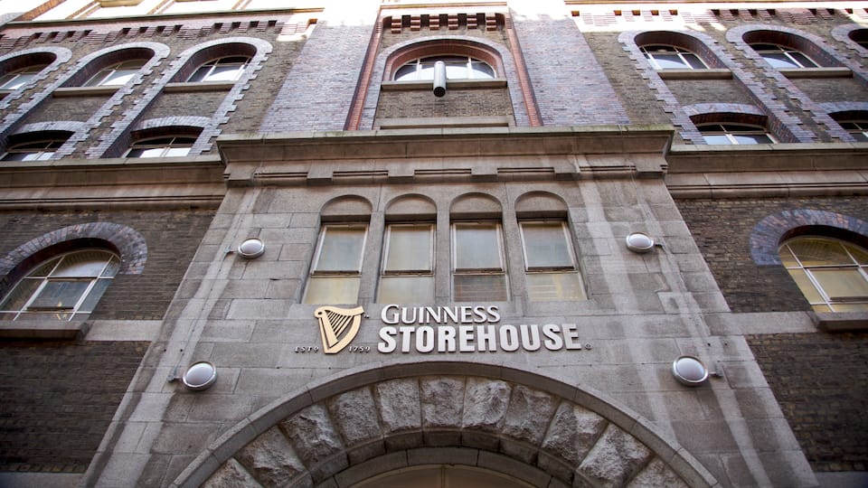 The exterior of the Guinness Storehouse building with its distinctive arched windows and stone facade.