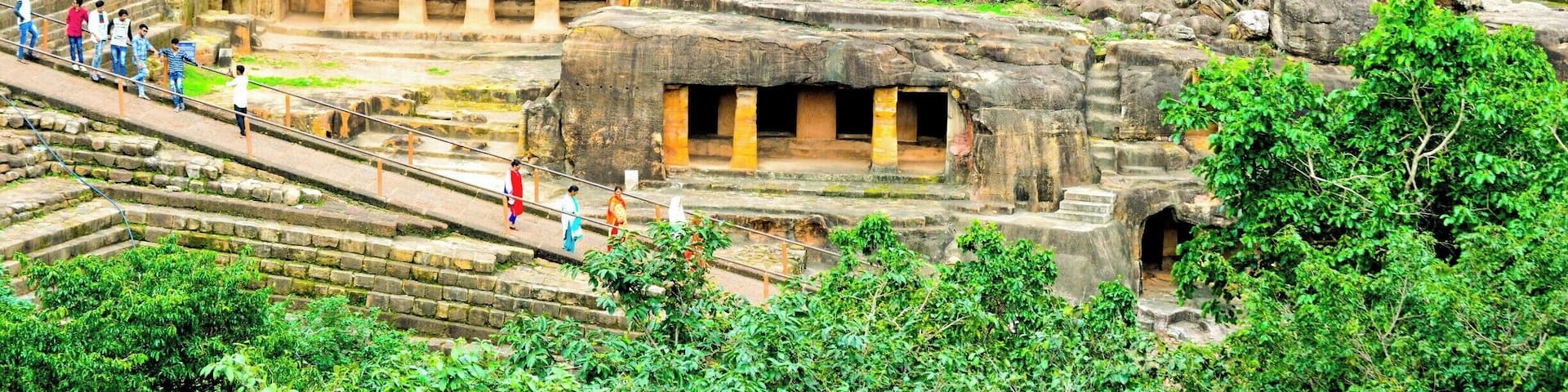 Ancient rock-cut architecture with visitors.