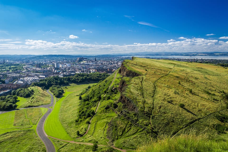 A cityscape with a prominent hill and winding roads.