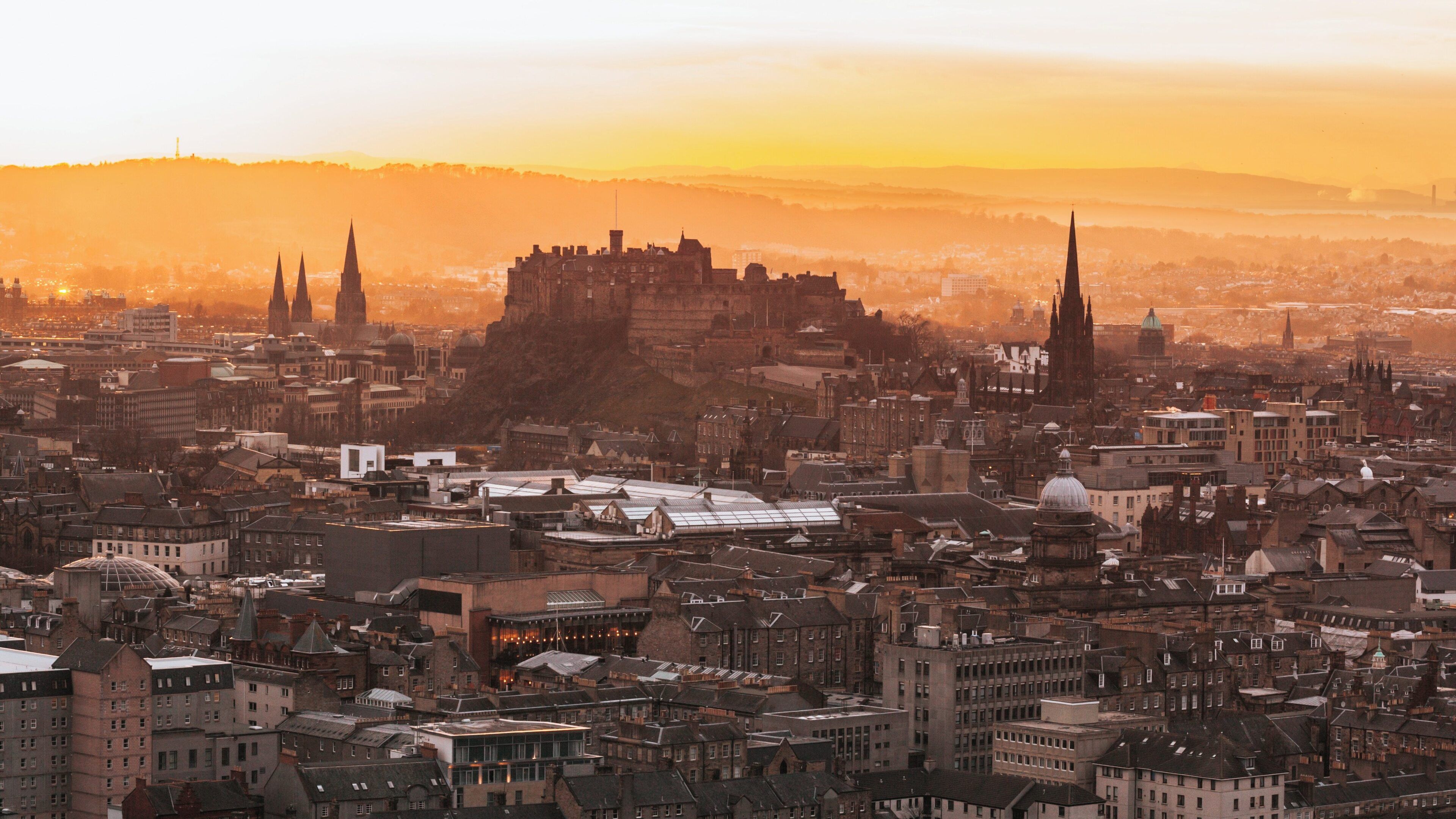 Sunset view from Arthur's Seat showcasing Edinburgh's skyline, highlighting historical architecture and natural beauty in Scotland