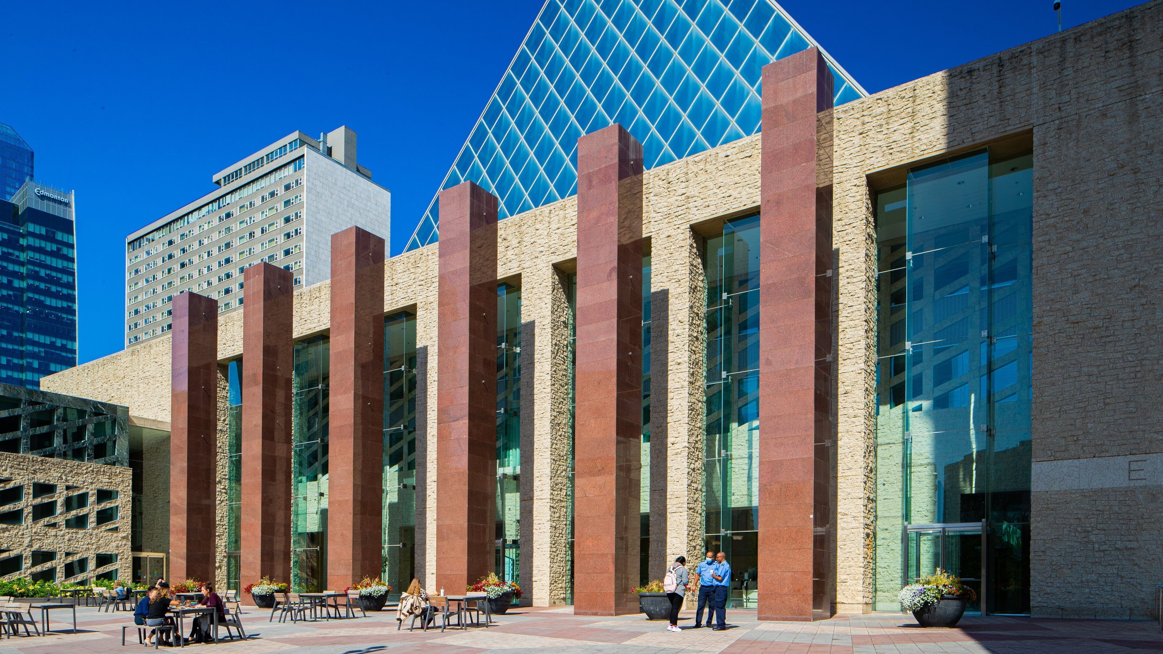 A modern building with large glass windows and a stone facade.
