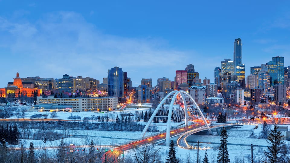Edmonton Downtown Skyline Just After Sunset in the Winter Showing Alberta Legislature and Walterdale Bridge Over the frozen Saskatchewan River