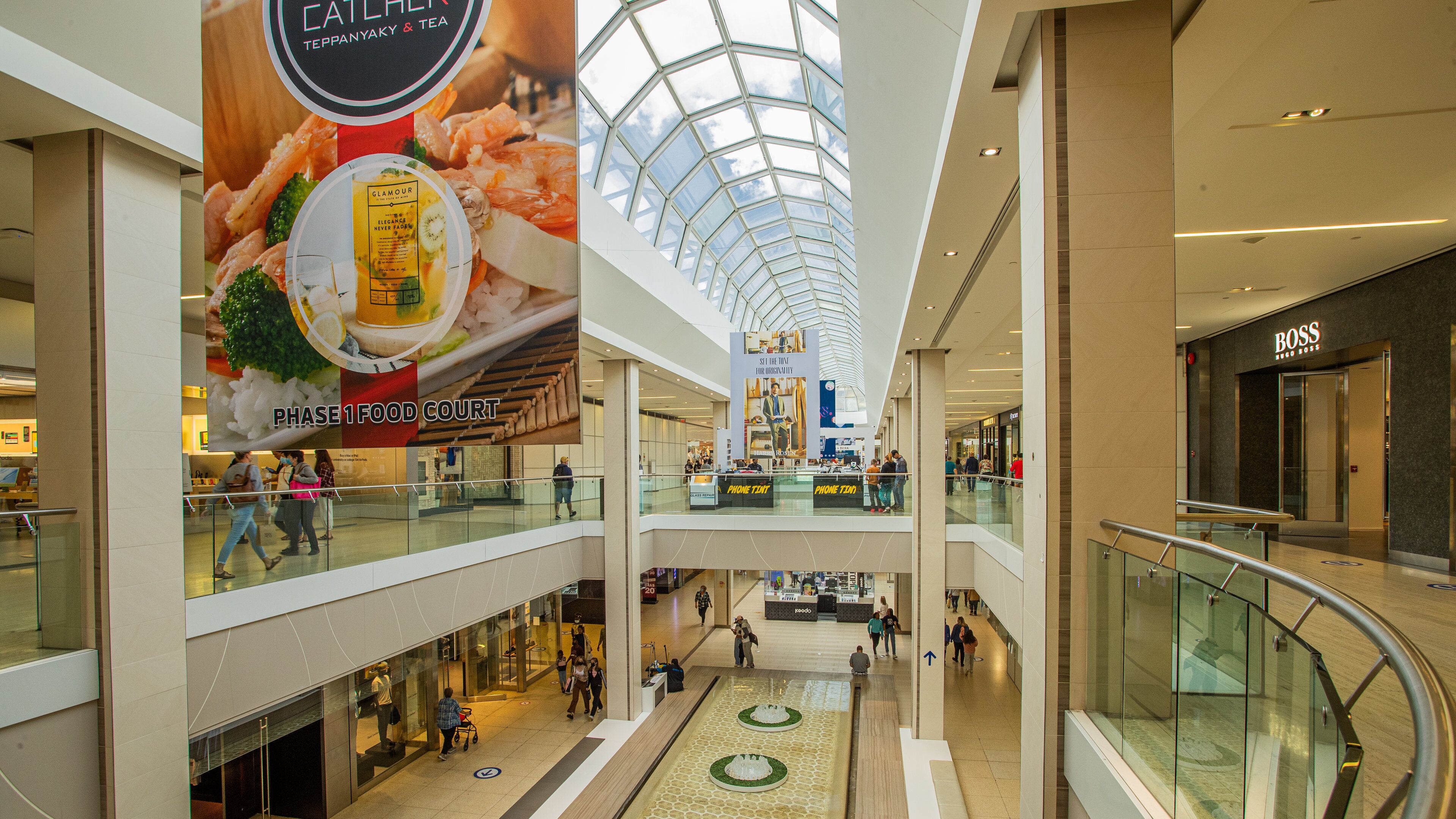 Un centro commerciale su più livelli con soffitto in vetro, un’area ristoro e numerosi negozi, tra cui Boss.
