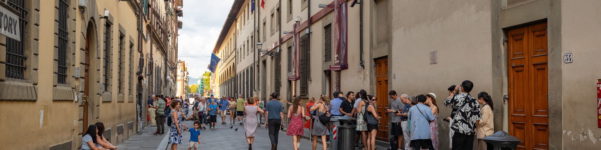 Gallery of the Academy of Florence showing street scenes as well as a large group of people