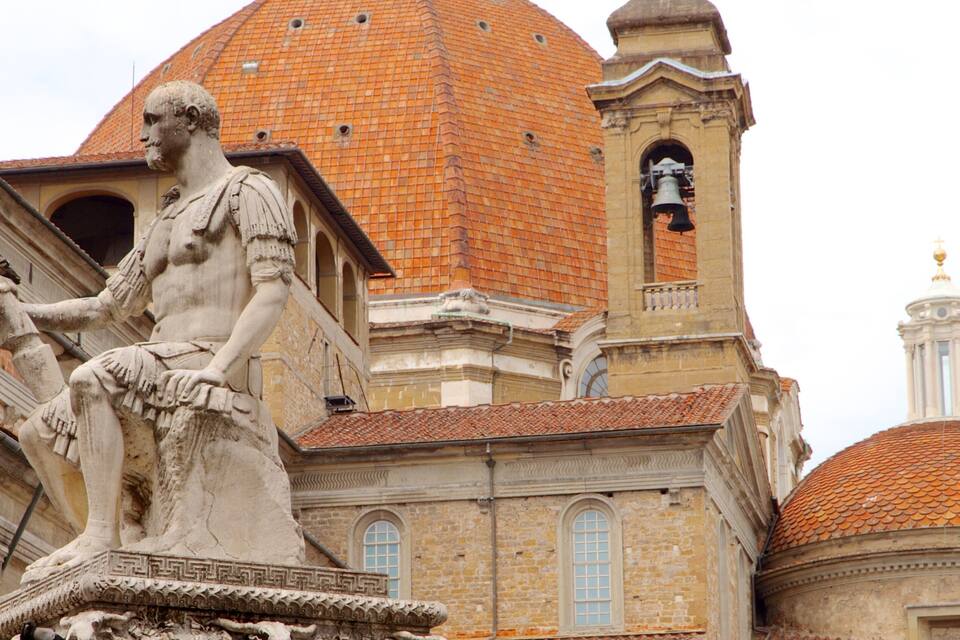 A classical statue, a church with a bell tower, and a dome.