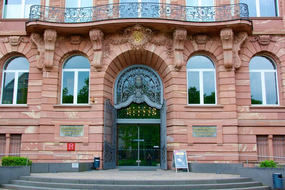 A historic building with ornate architecture, including a large arched entrance and decorative ironwork.