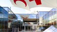A modern glass building with a large red and white logo, and the sign 'musée+cgenève'.