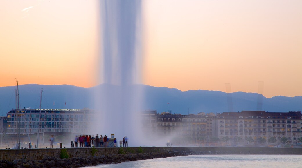 Jet d\'Eau Fountain showing a fountain and a sunset as well as a large group of people