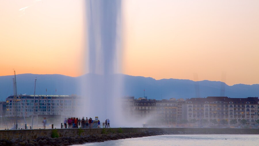 Jet d\'Eau Fountain showing a fountain and a sunset as well as a large group of people