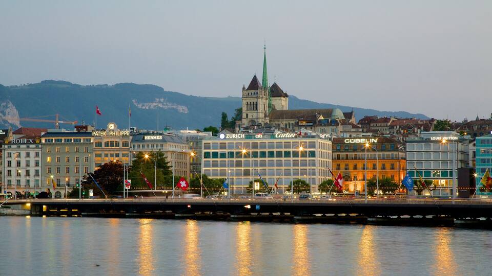 A cityscape with prominent buildings like Rolex, Hermes, and Louis Vuitton, reflecting on the water.