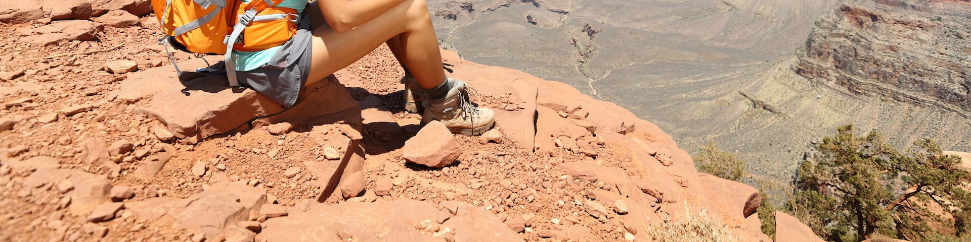 Tablet computer woman hiking in Grand Canyon using travel app or map during her hike. Multiethnic hiker girl relaxing on South Kaibab Trail, south rim of Grand Canyon, Arizona, USA.