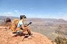 Tablet computer woman hiking in Grand Canyon using travel app or map during her hike. Multiethnic hiker girl relaxing on South Kaibab Trail, south rim of Grand Canyon, Arizona, USA.