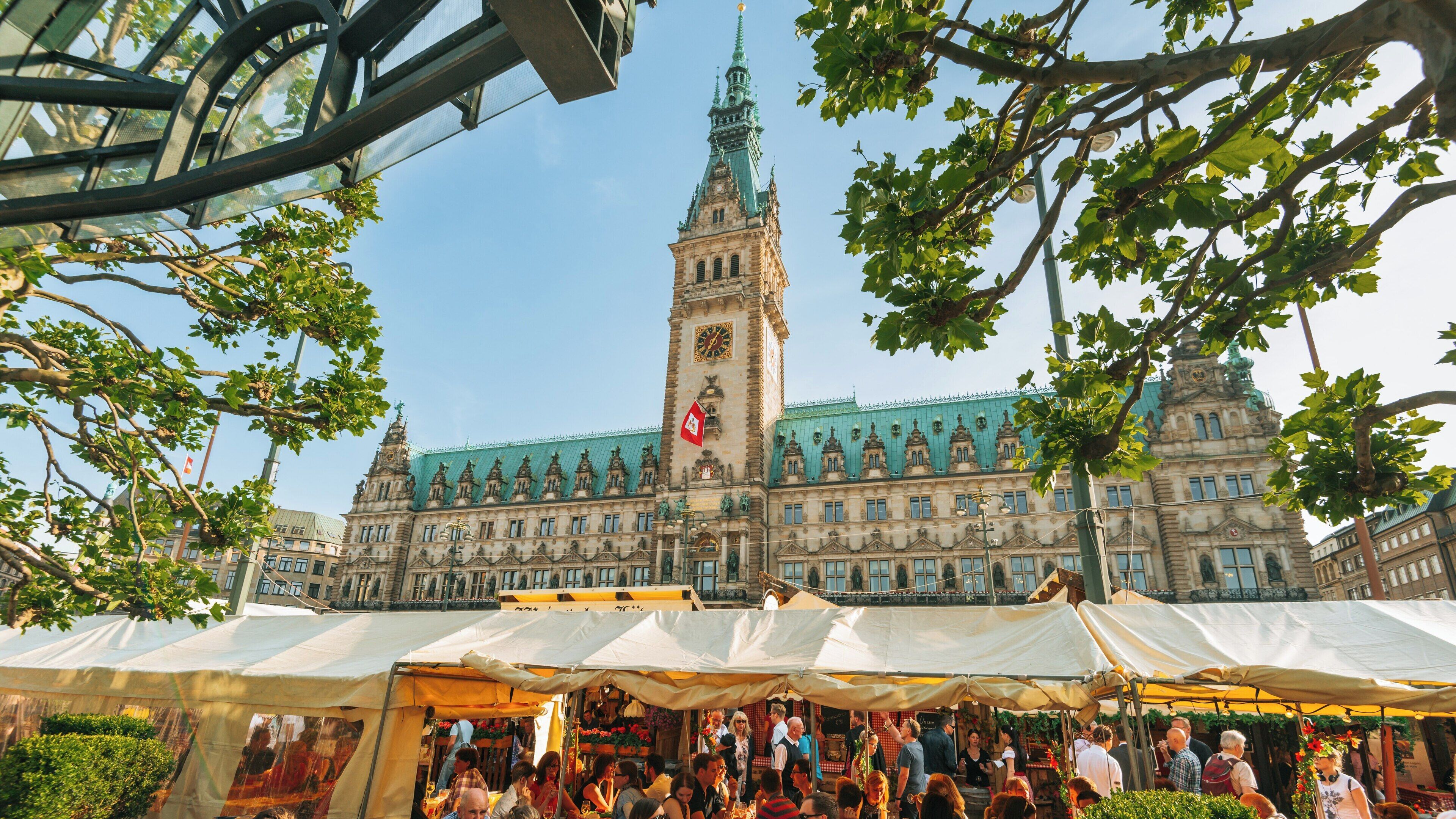 Visitors enjoy a vibrant market near Hamburg City Hall in Altstadt Hamburg on a sunny day in Germany