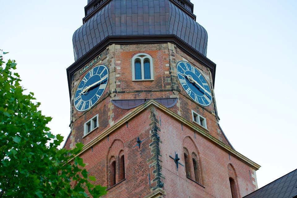 A clock tower with Roman numerals and a dome.