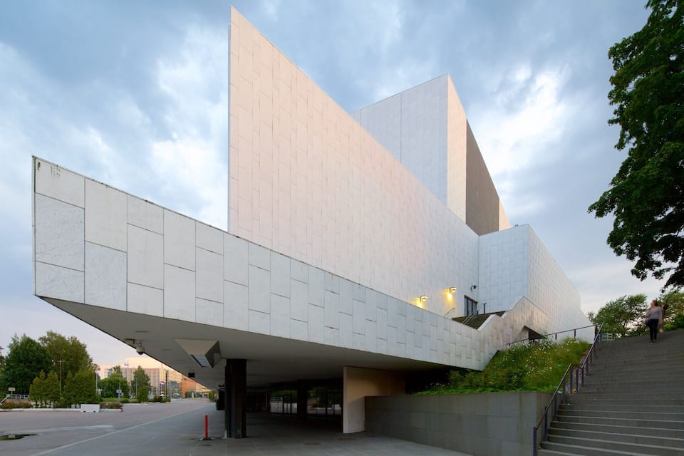 A modern architectural building with a sloped roof and large windows.