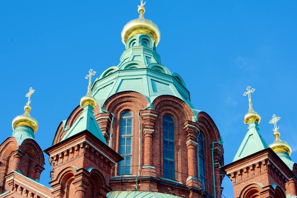 A church with a prominent green dome and golden crosses on its towers.