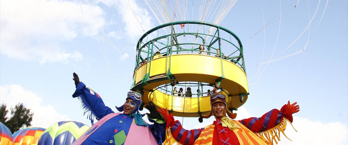 A colorful carnival ride with a yellow circular platform and passengers.