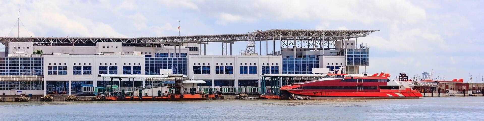 Passenger boat - arrives to Macao - Macau Harbour Ferry Terminal and red turbojet boats in a beautiful blue sky; Shutterstock ID 668109466; purchase_order: SF 06557000; job: ; client: ; other: