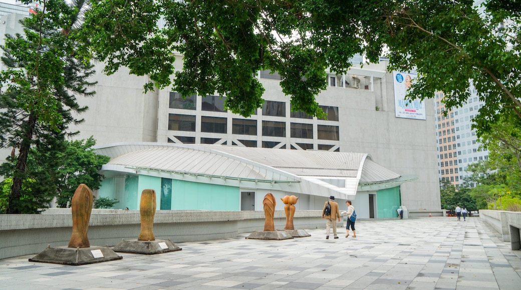 Hong Kong Academy for Performing Arts showing outdoor art and street scenes as well as a couple