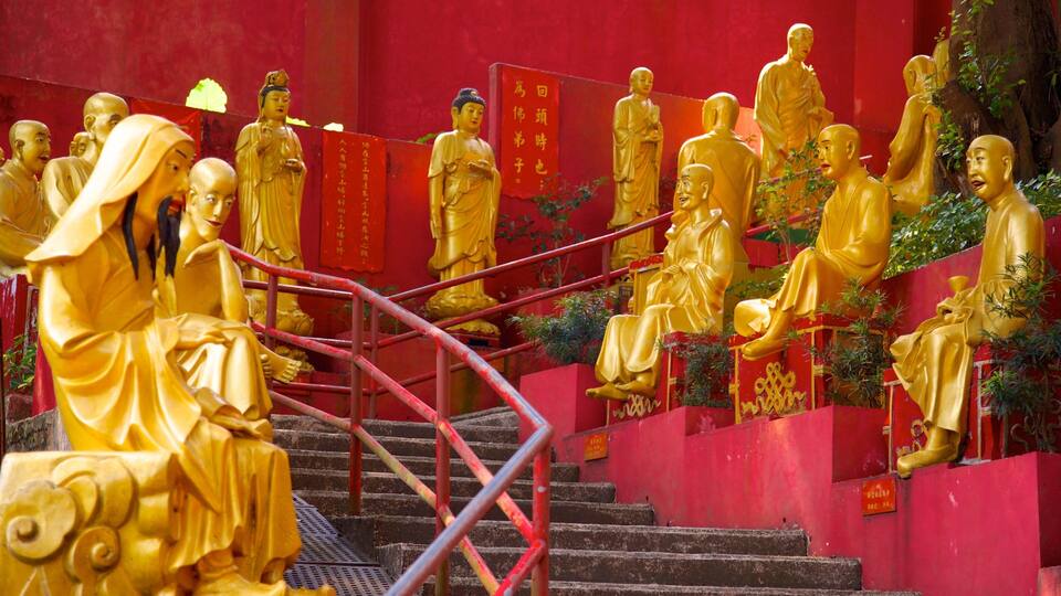 Golden statues of monks on a staircase.