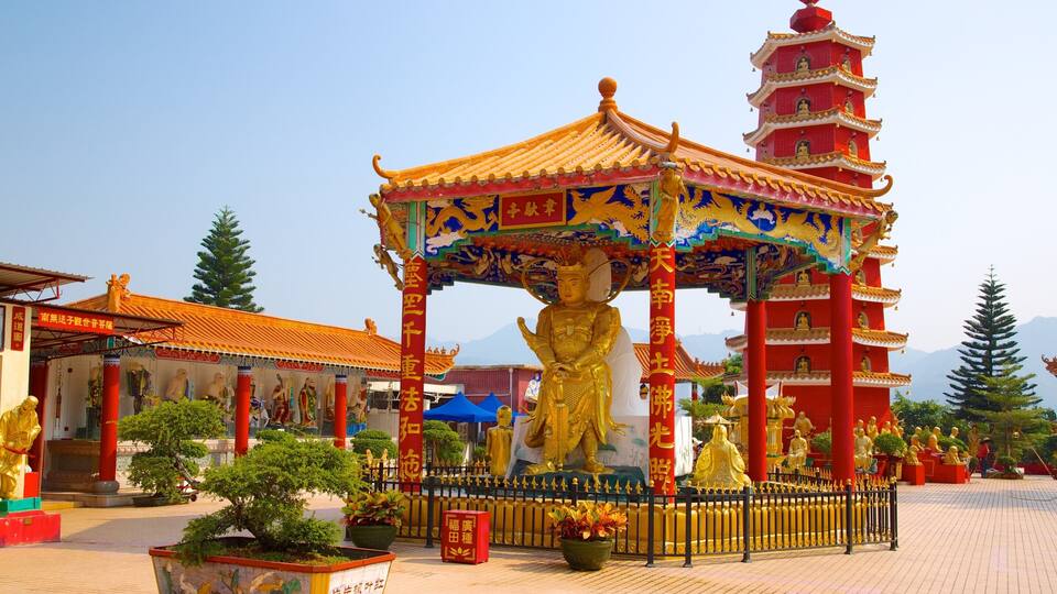 A traditional Chinese temple with a large golden statue, red and gold architecture, and a pagoda in the background.