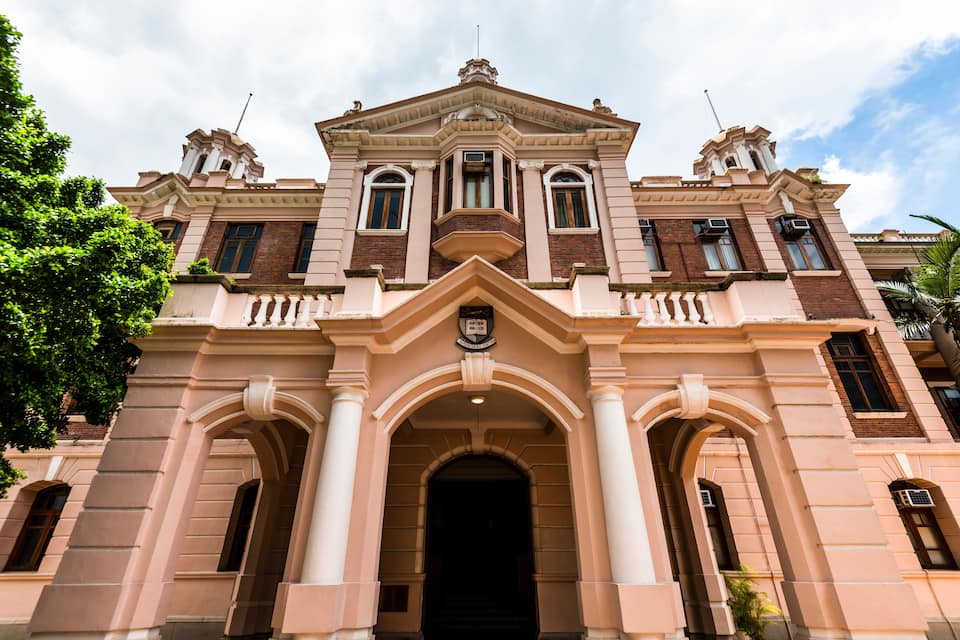 A grand building with a symmetrical facade, large arched entrance, and decorative elements.