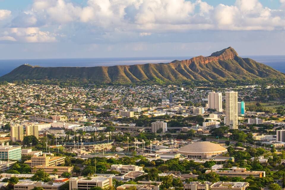 A cityscape with a prominent mountain in the background.
