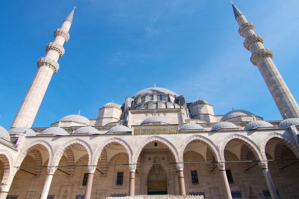 A mosque with two tall minarets and multiple domes.
