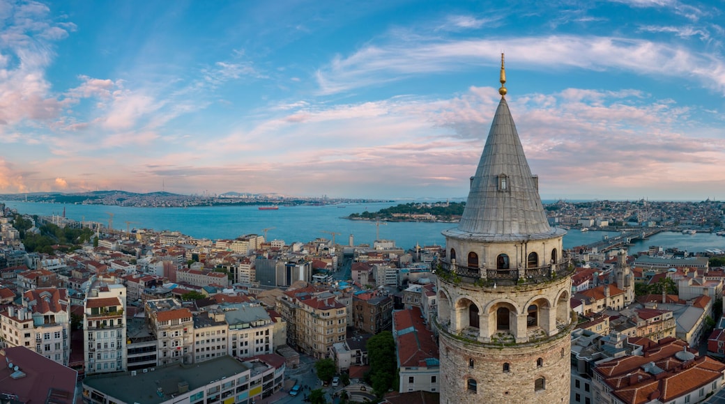 Panoramic view of Galata Tower and Istanbul Bosphorus with a cloudy sky.