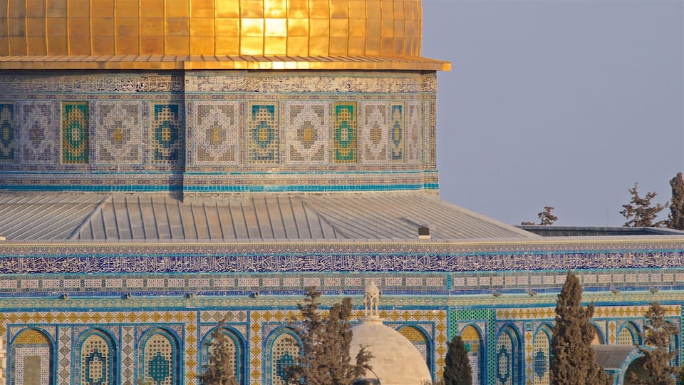 Uma mesquita com trabalhos em azulejos detalhados e uma cúpula dourada.