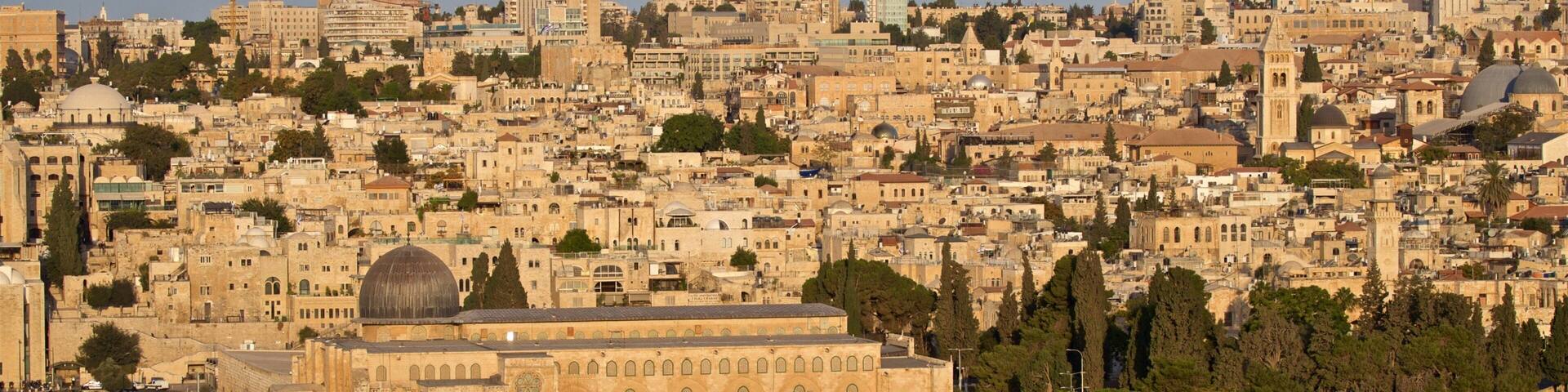 The Dome of the Rock in Jerusalem, surrounded by historic buildings and a dense urban landscape.