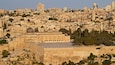 The Dome of the Rock in Jerusalem, surrounded by historic buildings and a dense urban landscape.