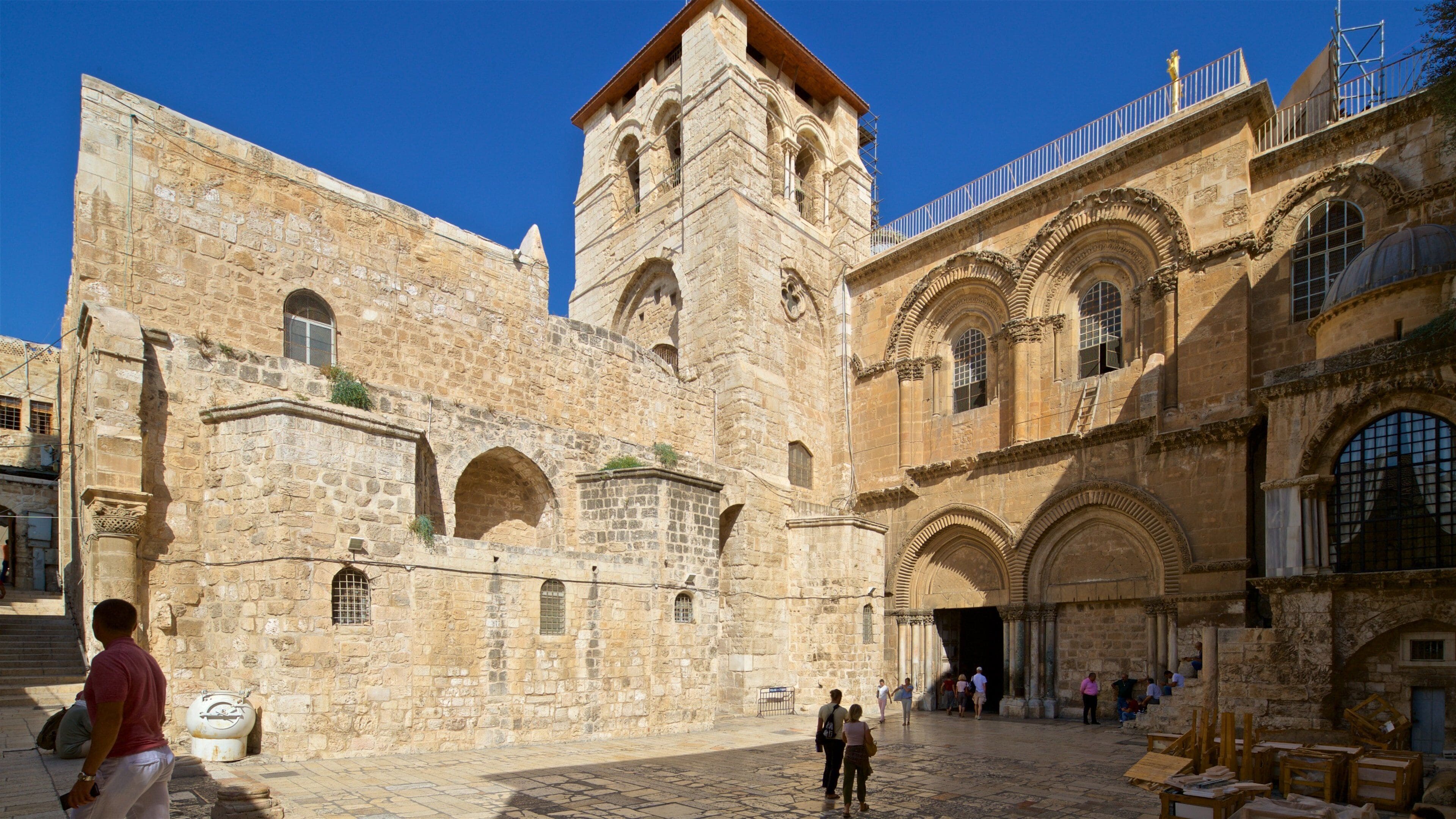 A historic stone building with arches and a tower.