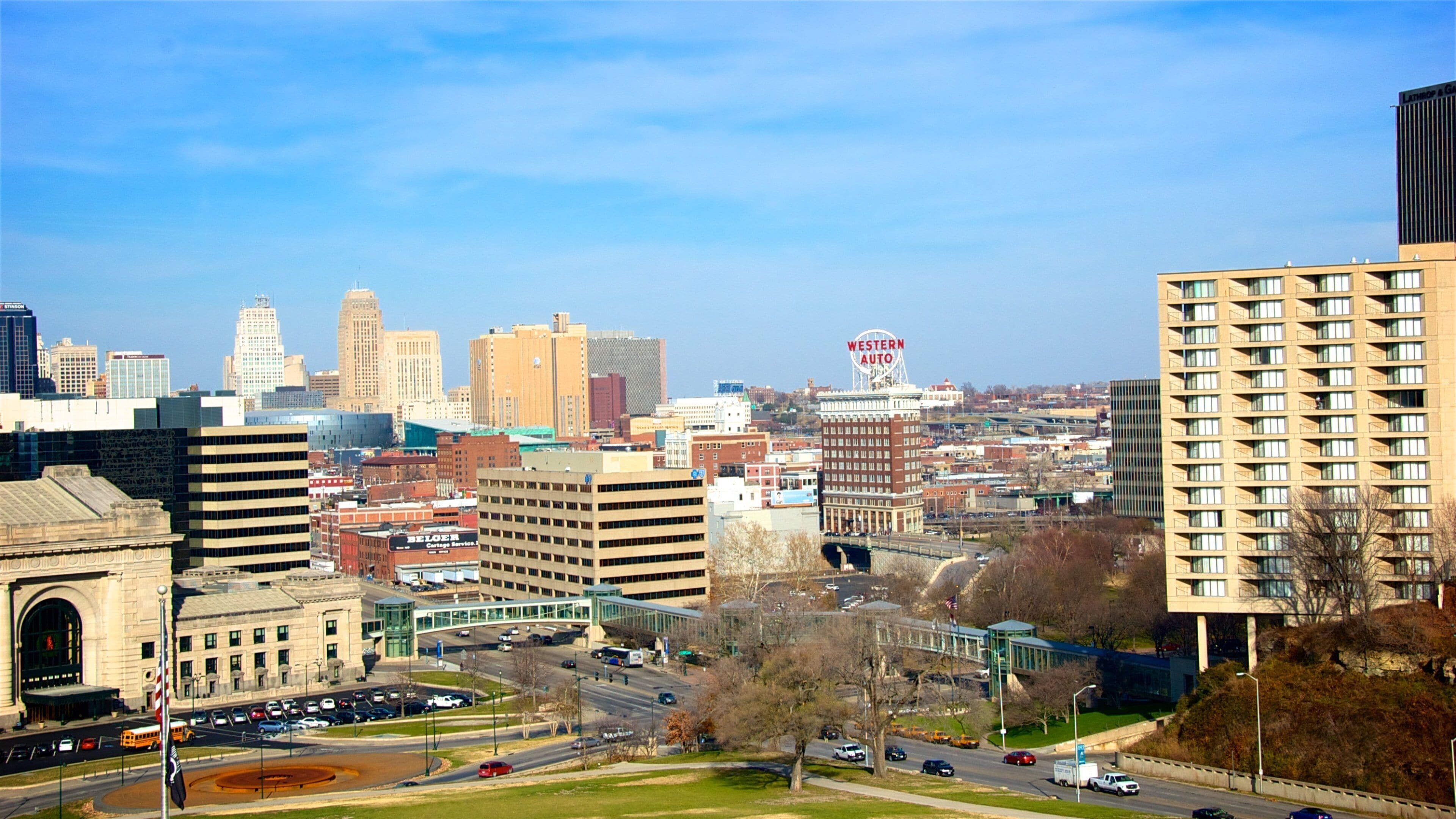 A cityscape with prominent buildings, a clear blue sky, and a sign for Western Auto.