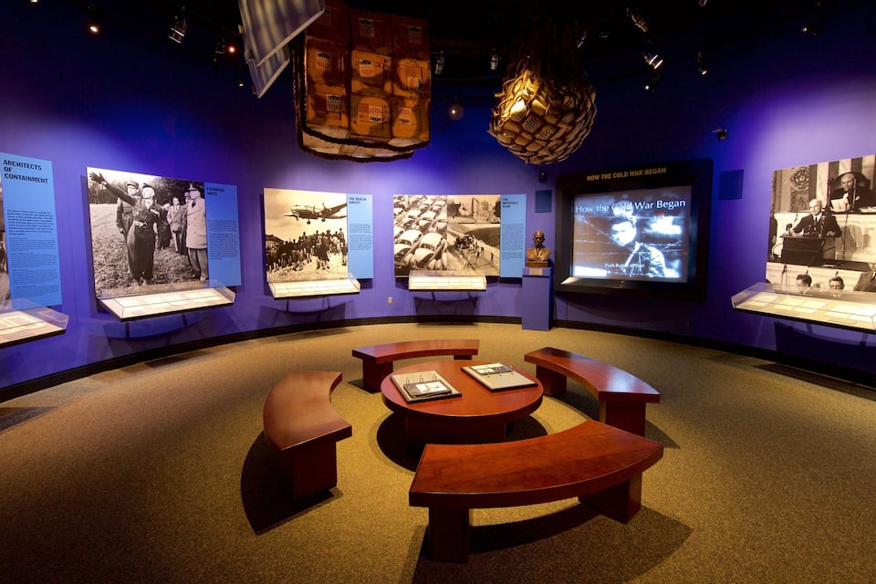 Una exposición de museo con fotografías históricas y paneles informativos.