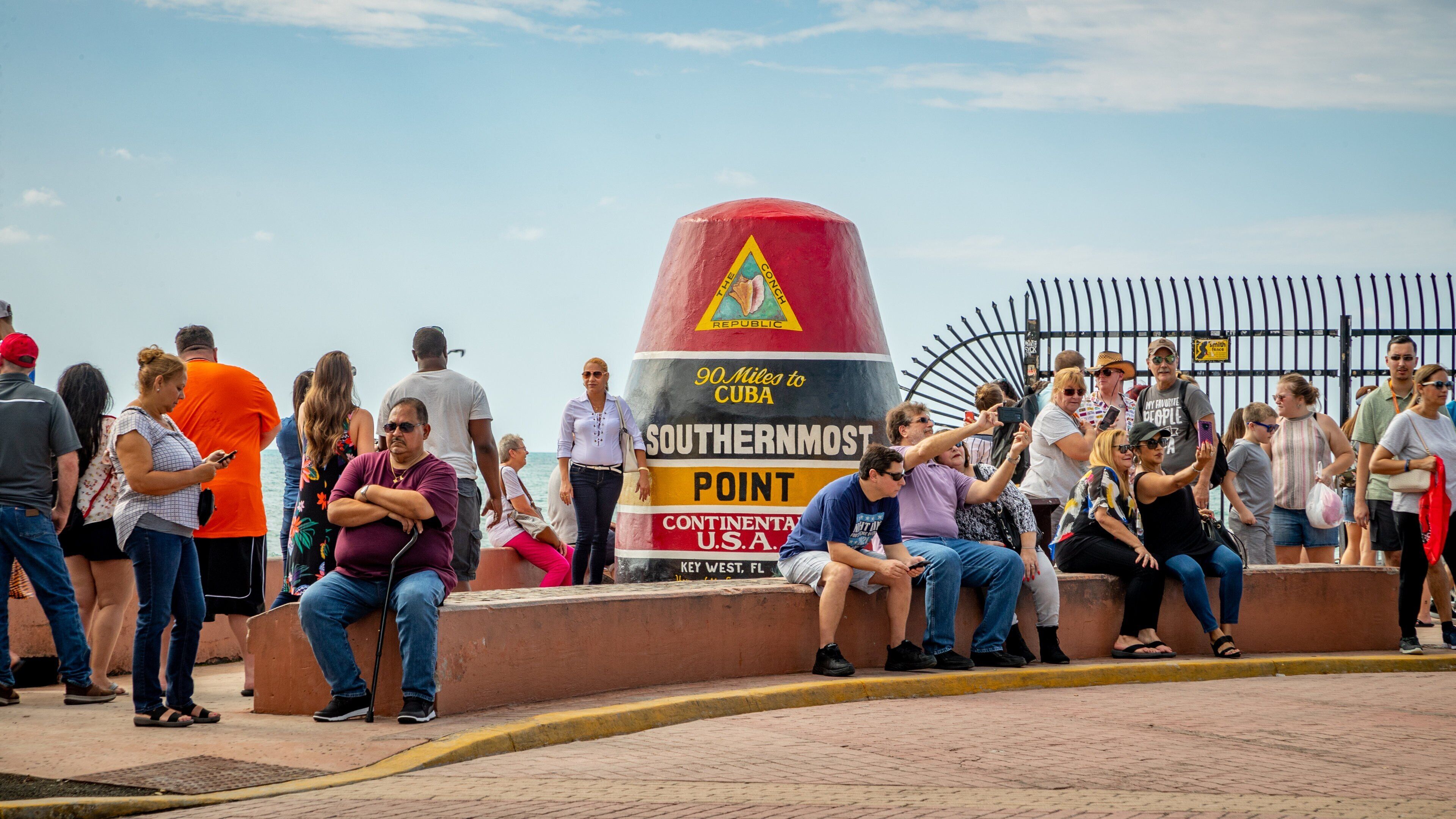 Southernmost Point featuring signage as well as a large group of people