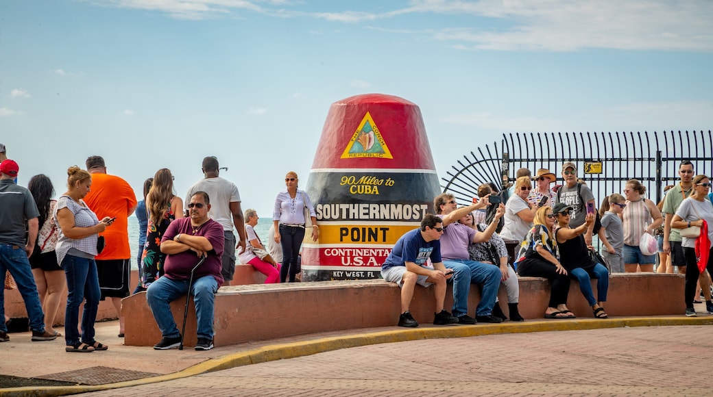Southernmost Point featuring signage as well as a large group of people