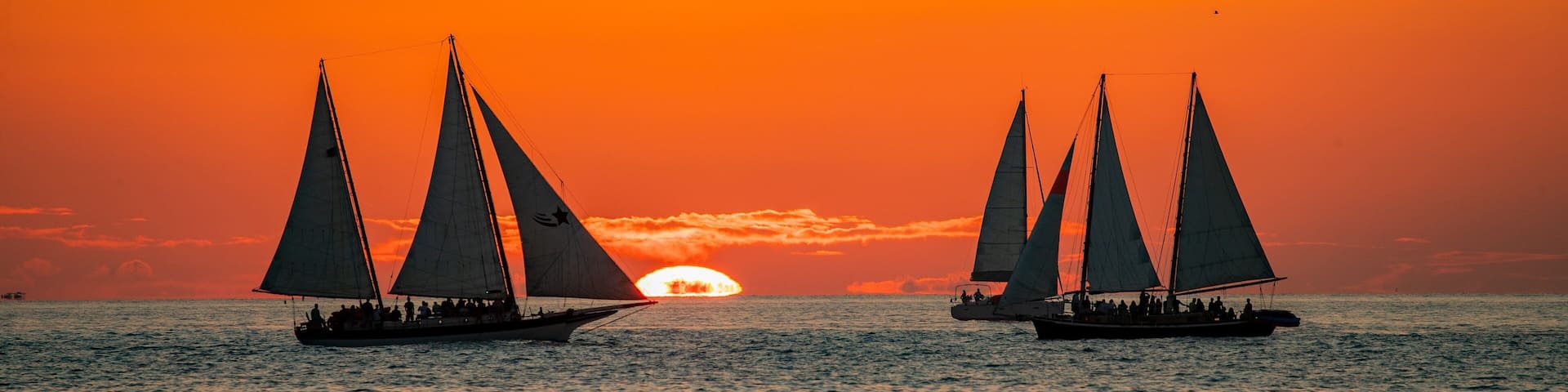 Mallory Square featuring general coastal views, a sunset and sailing