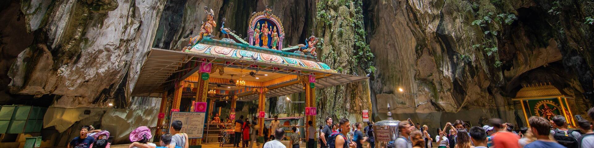 Batu Caves featuring caves and heritage elements as well as a large group of people