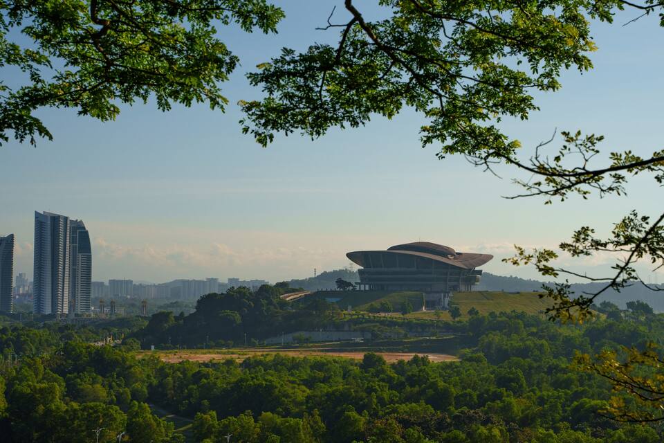 Paisagem urbana com edifícios modernos e uma estrutura arquitetônica marcante.