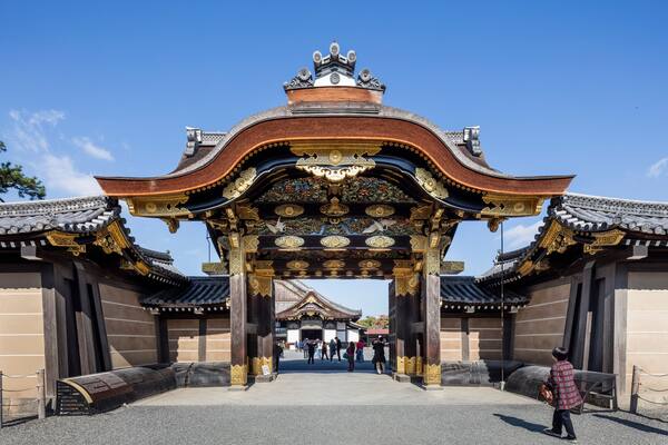 A traditional gate with ornate decorations and a clear blue sky above.