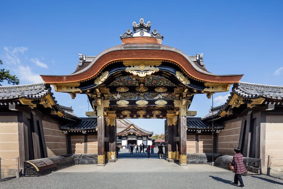 A traditional gate with ornate decorations and a clear blue sky above.
