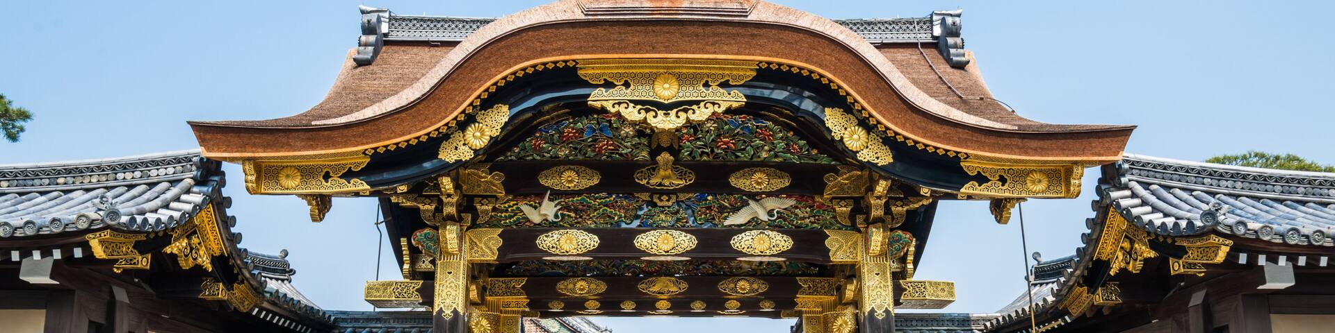 A traditional gate with ornate golden decorations and a tiled roof.