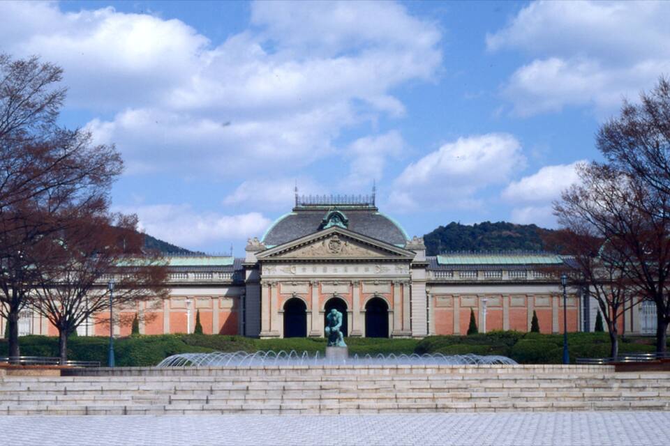 A classical building with a dome and columns, surrounded by trees and steps leading up to it.