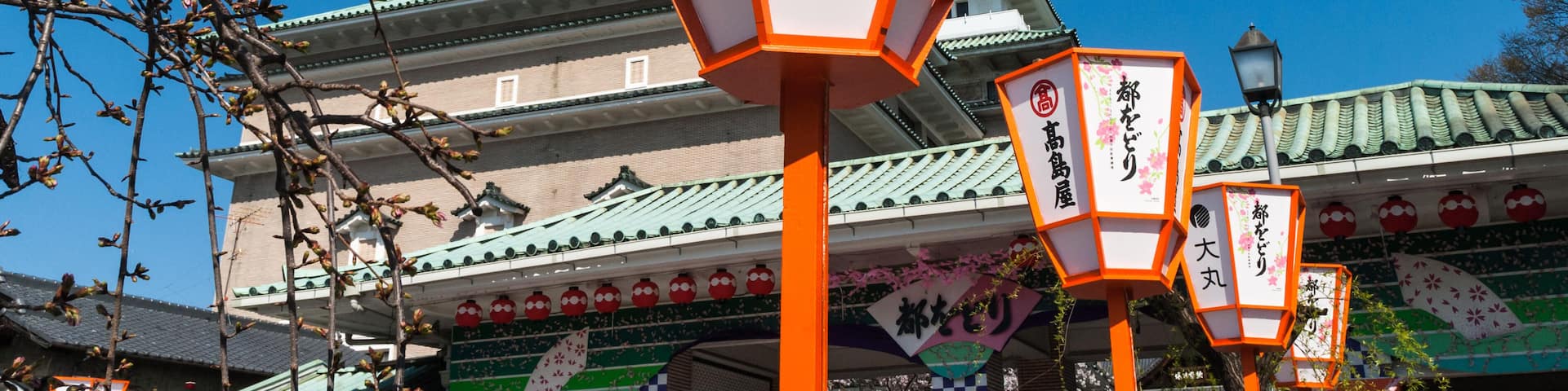 Traditional Japanese architecture with ornate lanterns and signage.