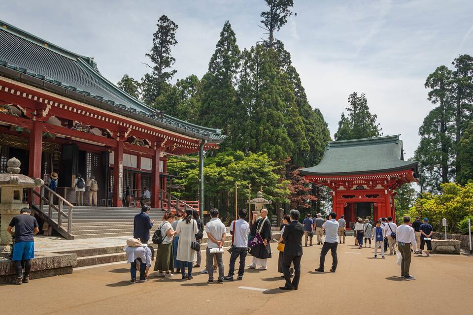 Un templo japonés tradicional con torii rojos y un farol de piedra.