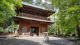 A traditional wooden pagoda surrounded by lush greenery.