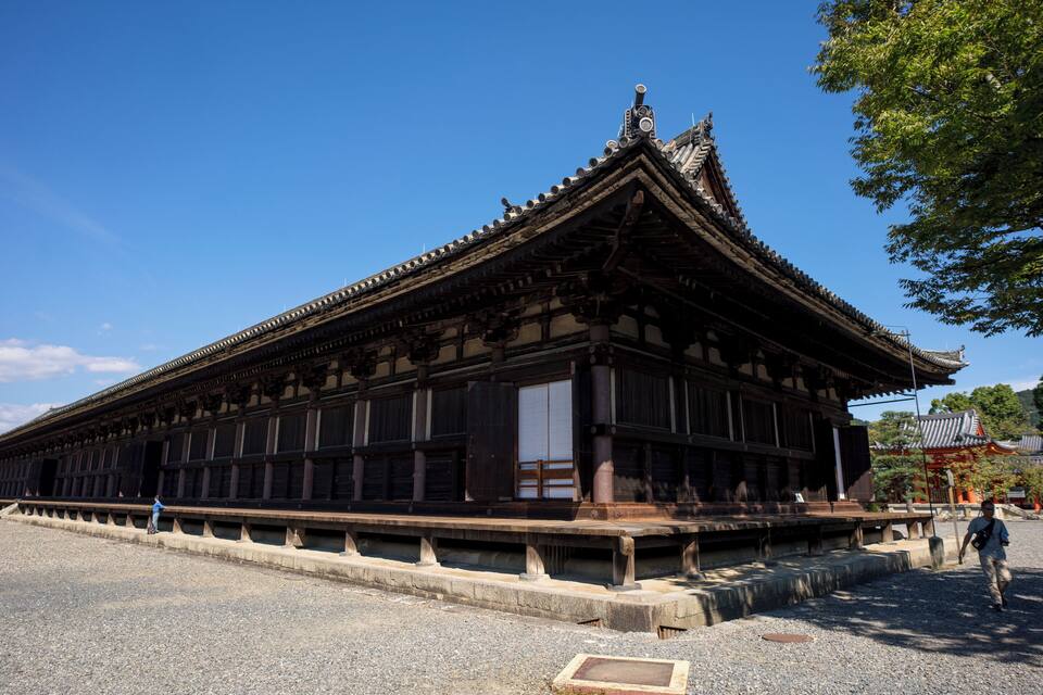 A traditional wooden building with a tiled roof and a stone base.